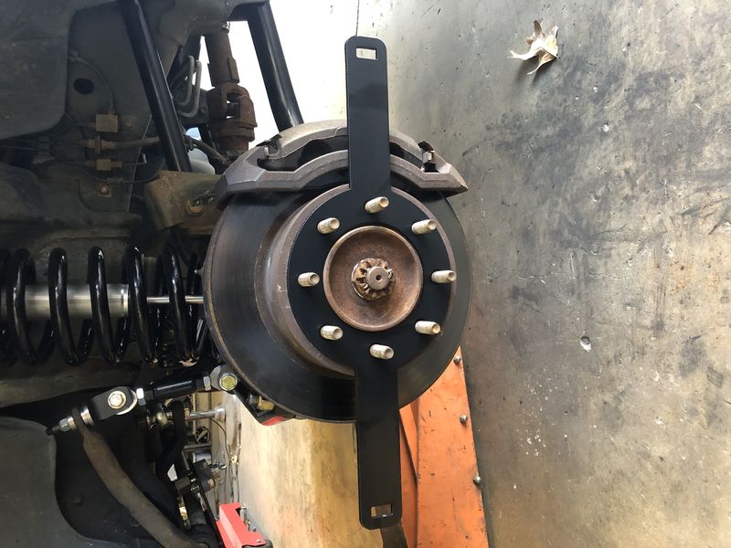 Dodge Off Road alignment plate bolted to a front hub for measuring toe at home
